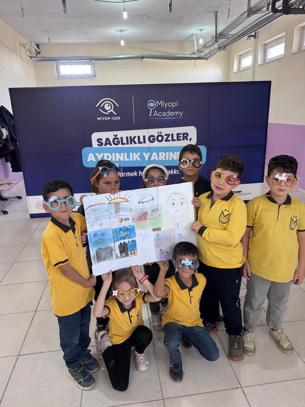 Kağıt gözlüklerle resimlerini gösteren çocuklar